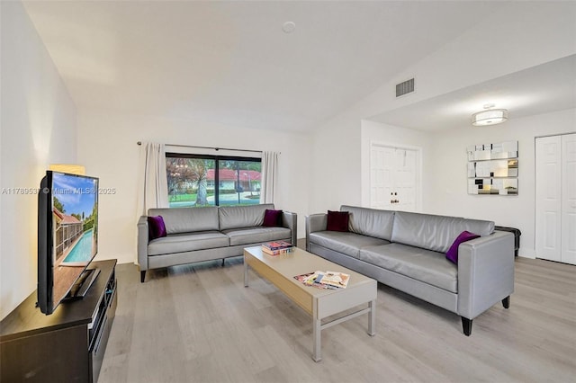 living area featuring light wood finished floors and vaulted ceiling