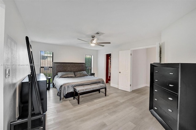 bedroom with light wood-style floors, ceiling fan, baseboards, and a spacious closet
