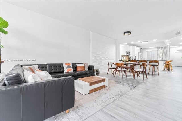 10730 NW 66 Unit 101, Doral, FL 33178 - living area featuring wood finished floors and a textured ceiling