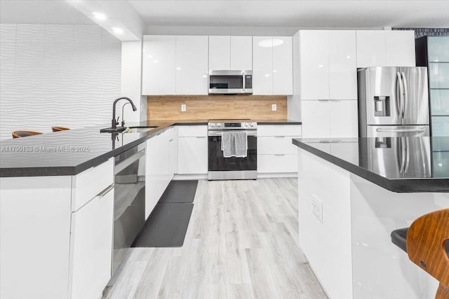 10730 NW 66 Unit 101, Doral, FL 33178 - kitchen with appliances with stainless steel finishes, a sink, modern cabinets, dark countertops, and white cabinetry