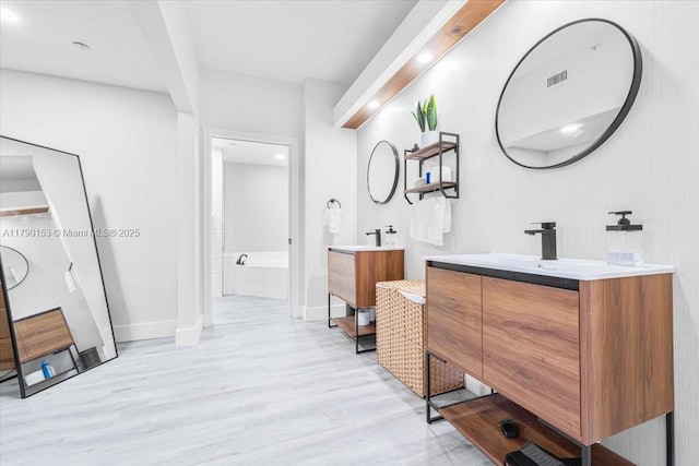 10730 NW 66 Unit 101, Doral, FL 33178 - full bathroom with wood finished floors, two vanities, baseboards, and recessed lighting
