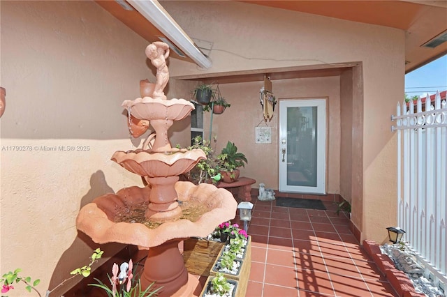doorway to property with stucco siding and fence