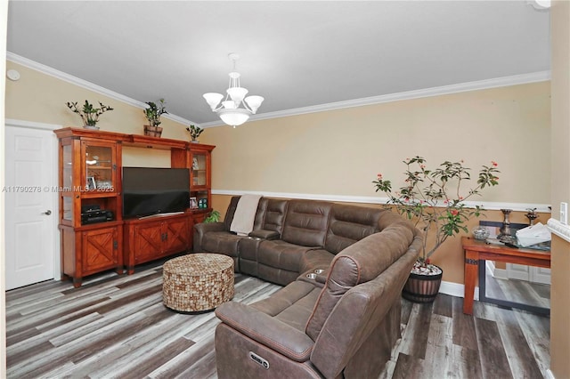living area featuring baseboards, ornamental molding, wood finished floors, and a notable chandelier