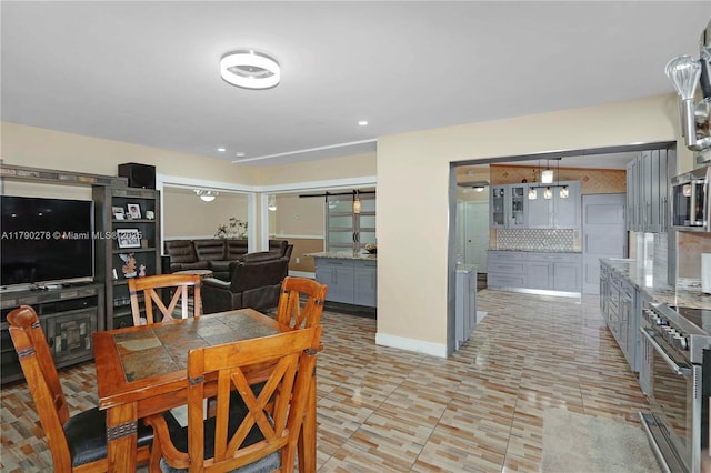 dining space with baseboards, recessed lighting, and a barn door