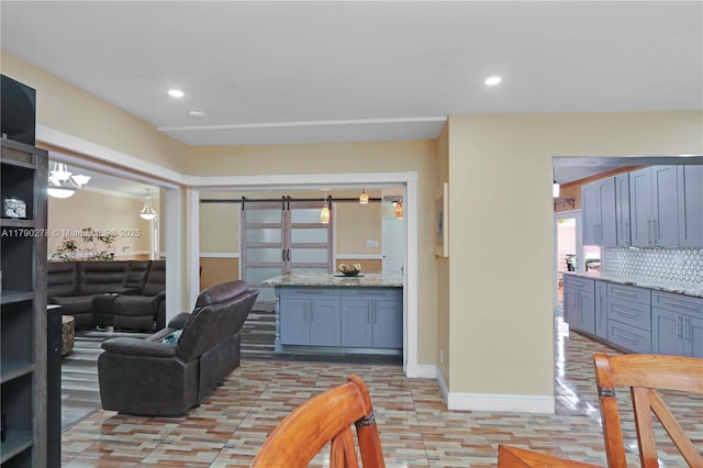 living area featuring recessed lighting, baseboards, and a barn door