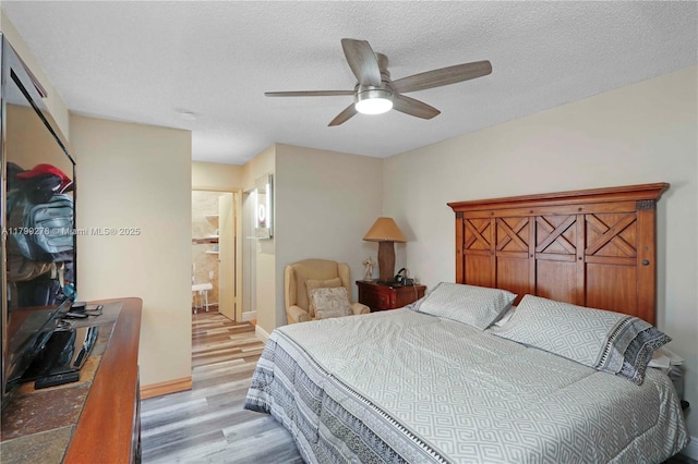 bedroom with light wood-type flooring, a textured ceiling, baseboards, and ceiling fan
