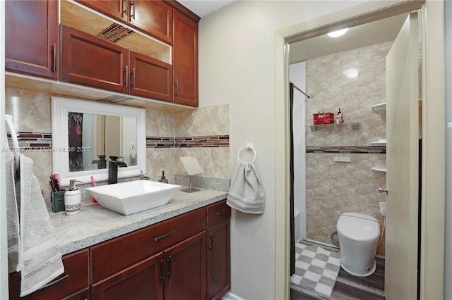 full bath with tasteful backsplash, walk in shower, tile patterned floors, vanity, and toilet