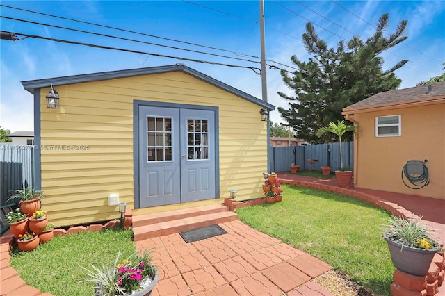 view of outdoor structure featuring fence and an outbuilding