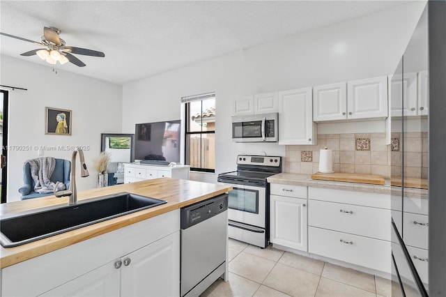 13995 S Cypress Cove Cir, Davie, FL 33325 - kitchen with appliances with stainless steel finishes, ceiling fan, tasteful backsplash, butcher block countertops, and white cabinets