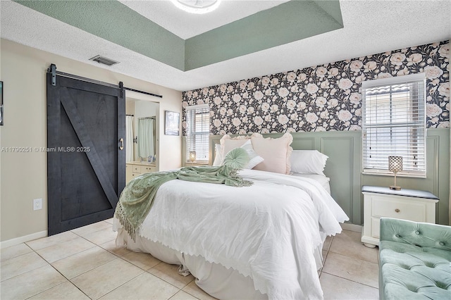 13995 S Cypress Cove Cir, Davie, FL 33325 - bedroom with a barn door, a textured ceiling, multiple windows, wallpapered walls, and light tile patterned floors