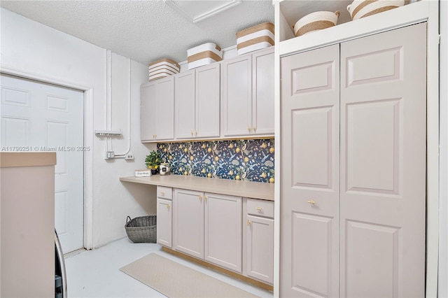 13995 S Cypress Cove Cir, Davie, FL 33325 - kitchen featuring light countertops, tasteful backsplash, white cabinetry, a textured ceiling, and built in study area