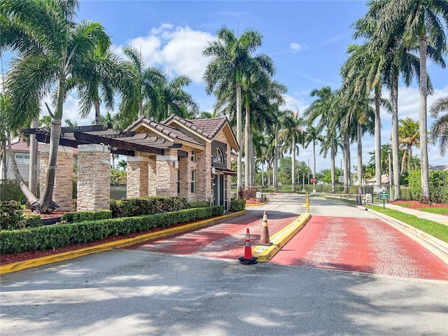 13995 S Cypress Cove Cir, Davie, FL 33325 - view of asphalt road featuring curbs, traffic signs, a gated entry, and sidewalks