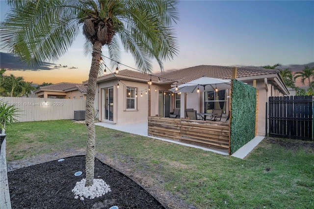 13995 S Cypress Cove Cir, Davie, FL 33325 - back of property with a tiled roof, stucco siding, a fenced backyard, and a patio