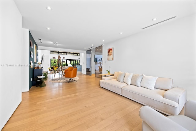 living room with visible vents, recessed lighting, and light wood-style flooring
