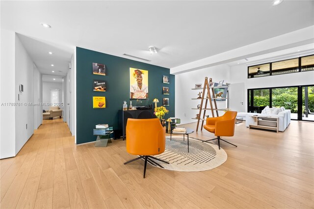 living area with light wood-type flooring and recessed lighting