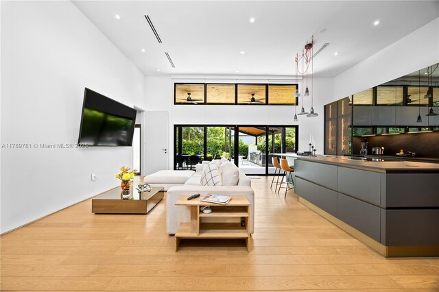 288 NE 117th St, Miami, FL 33161 - living room featuring a towering ceiling, light wood-type flooring, and recessed lighting