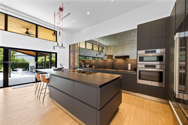 288 NE 117th St, Miami, FL 33161 - kitchen with stainless steel double oven, dark countertops, modern cabinets, backsplash, and black electric stovetop