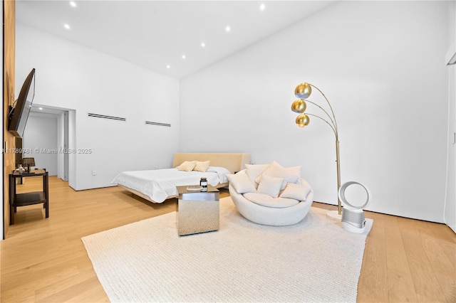 bedroom with light wood-style flooring, recessed lighting, and high vaulted ceiling