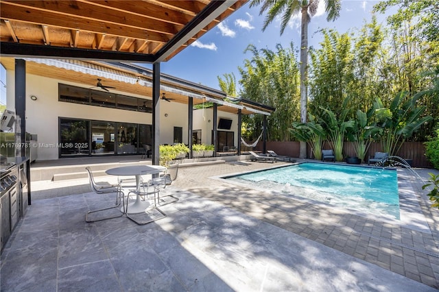 view of swimming pool featuring a patio, a ceiling fan, a fenced in pool, and fence