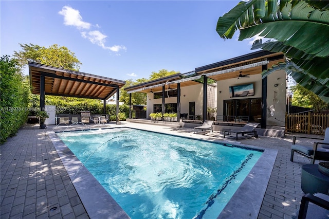 view of swimming pool with ceiling fan, a fenced in pool, and a patio area