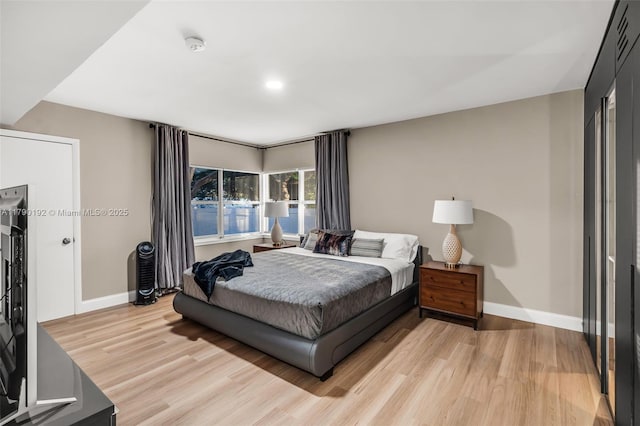 bedroom with light wood-style flooring and baseboards