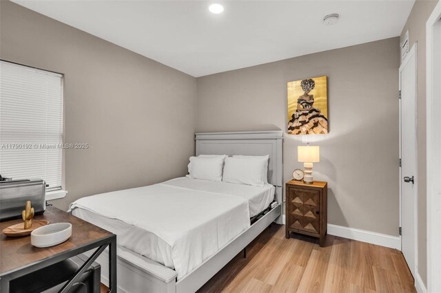 bedroom with baseboards, light wood-style floors, and recessed lighting