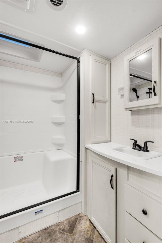 bathroom featuring walk in shower and vanity