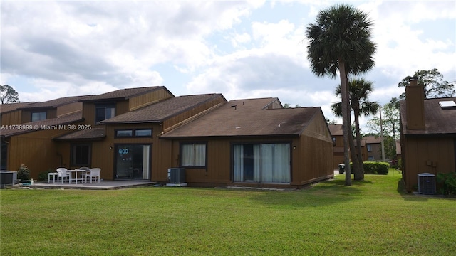 rear view of house with cooling unit, a patio, and a yard