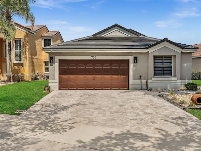ranch-style house featuring a garage, driveway, a front lawn, and stucco siding