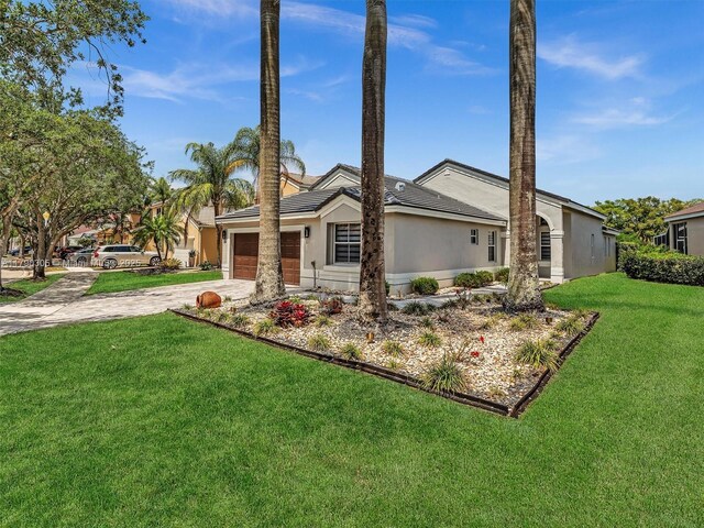 view of front of property with stucco siding, an attached garage, driveway, and a front lawn