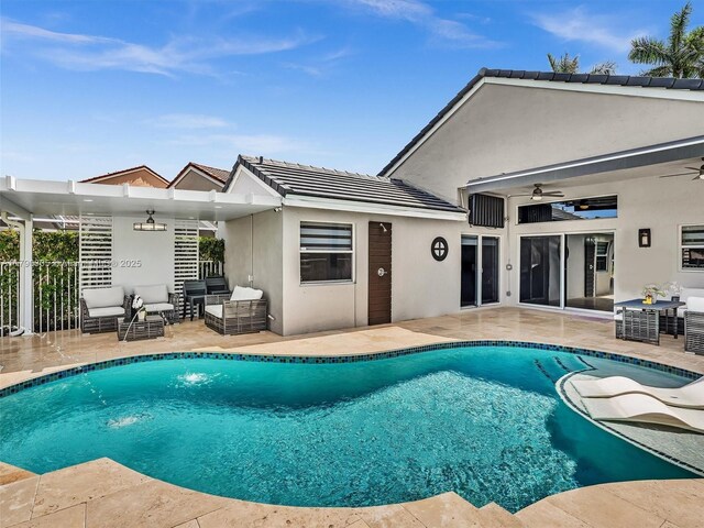 pool featuring a patio area, outdoor lounge area, fence, and a ceiling fan