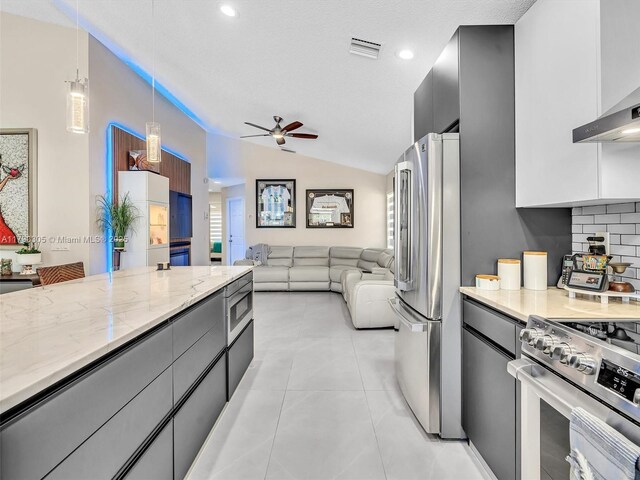 kitchen featuring a ceiling fan, modern cabinets, lofted ceiling, appliances with stainless steel finishes, and visible vents