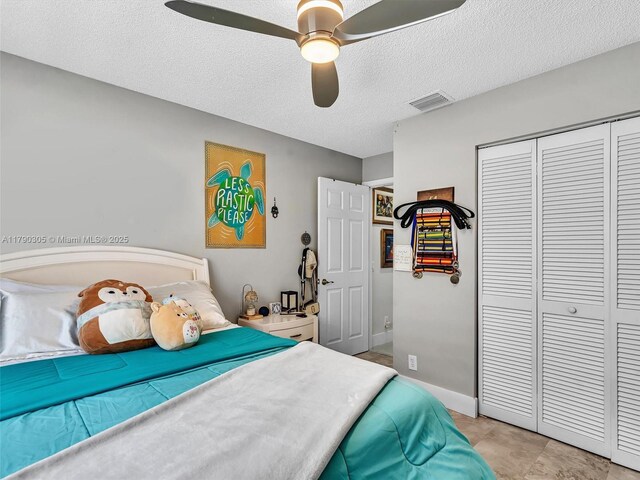 bedroom with a textured ceiling, a closet, a ceiling fan, and visible vents