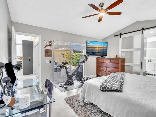 bedroom with a barn door, access to exterior, vaulted ceiling, baseboards, and ceiling fan