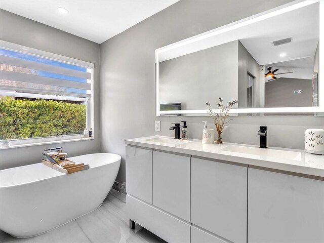 bathroom with marble finish floor, a sink, visible vents, and double vanity