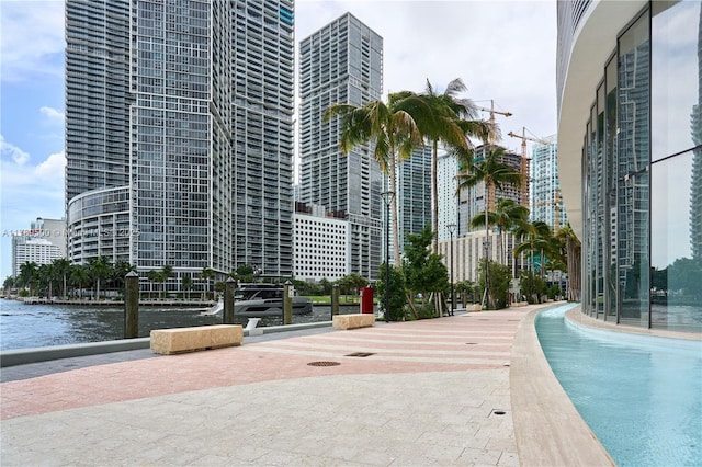 view of pool with a view of city and a water view