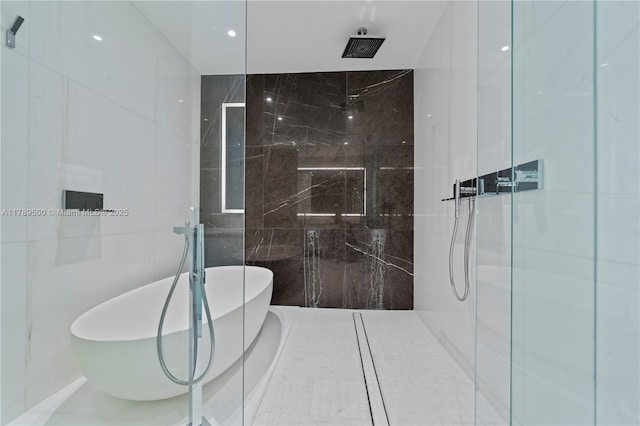 full bathroom featuring tile walls, a freestanding bath, and a marble finish shower