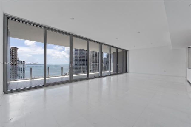 spare room featuring tile patterned flooring and a water view