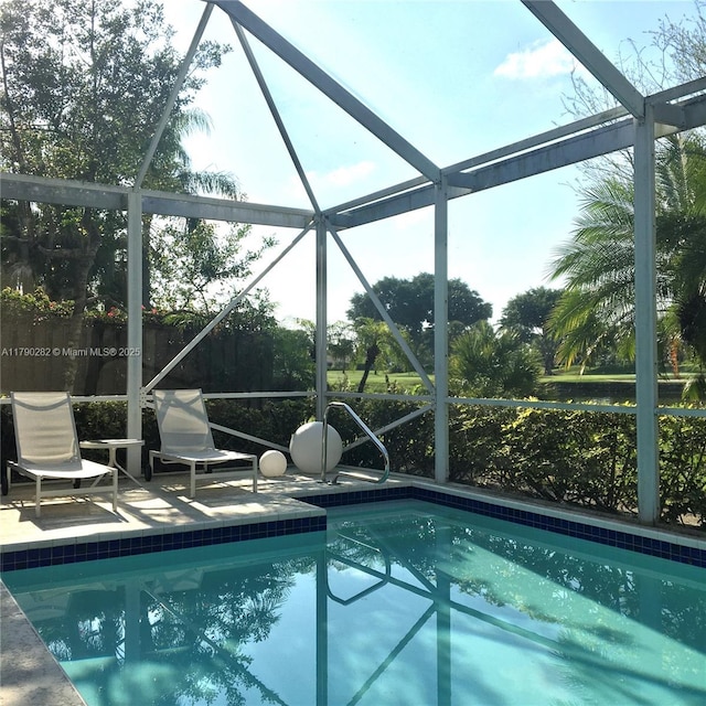 outdoor pool with a patio and a lanai