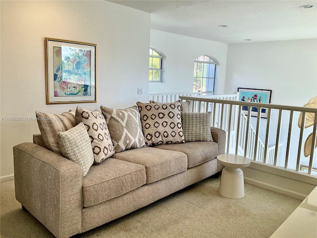 carpeted living area featuring baseboards