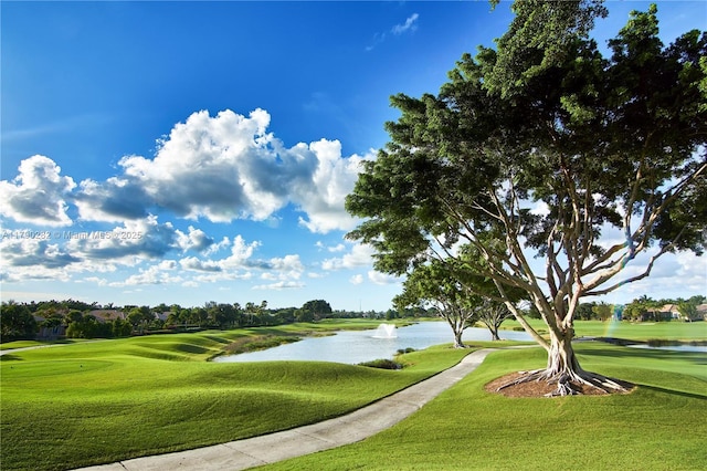 view of community with a yard, golf course view, and a water view