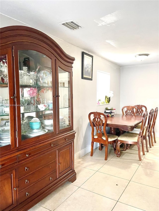 dining area with light tile patterned floors, visible vents, and baseboards