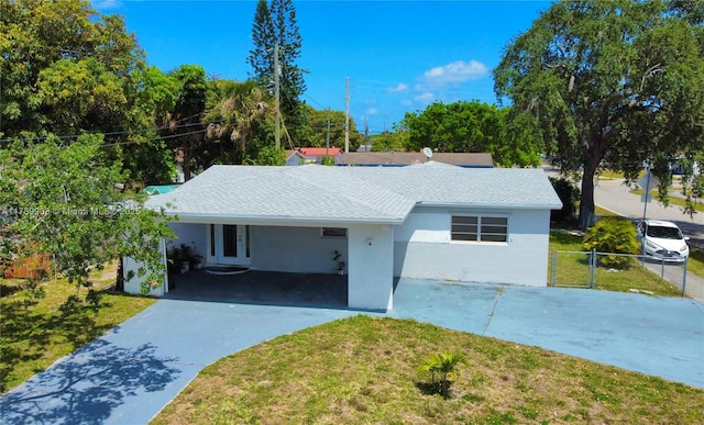 single story home with stucco siding, fence, an attached carport, driveway, and a front yard