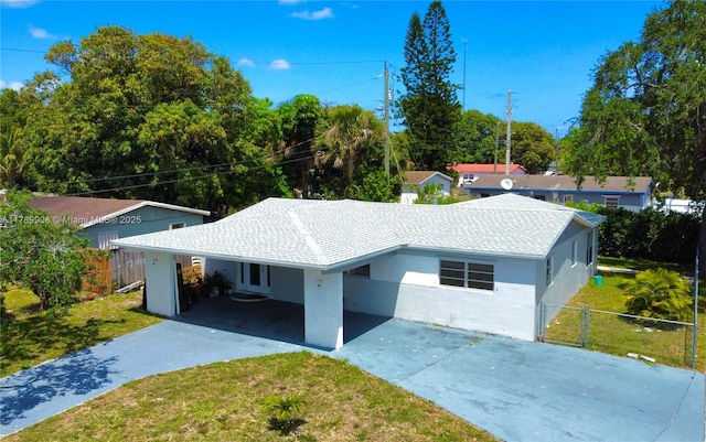 ranch-style home with fence, a front lawn, concrete driveway, and an attached carport
