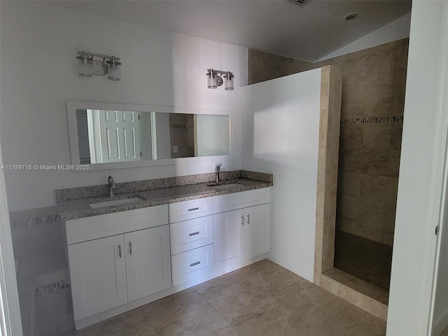 bathroom with walk in shower, double vanity, a sink, and tile patterned floors