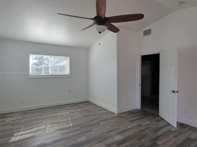 spare room with lofted ceiling, visible vents, ceiling fan, baseboards, and wood finished floors