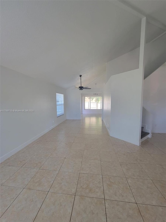 empty room featuring light tile patterned floors, ceiling fan, and vaulted ceiling