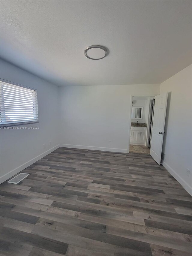 empty room featuring wood finished floors and baseboards