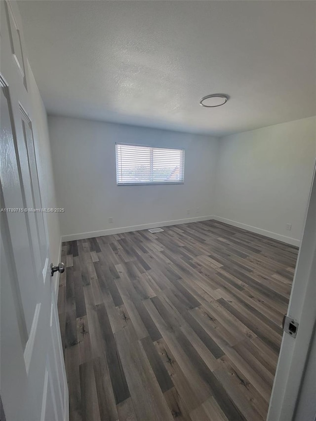 empty room with wood finished floors and baseboards