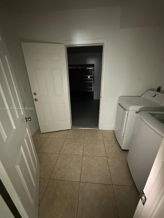 washroom featuring light tile patterned floors, separate washer and dryer, and laundry area